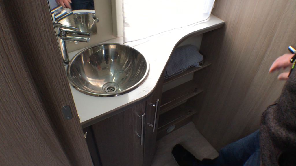 Den externe håndvask sidder i hjørnet mellem garderobeskabet, hyldeskabet og bade/toiletrummet.