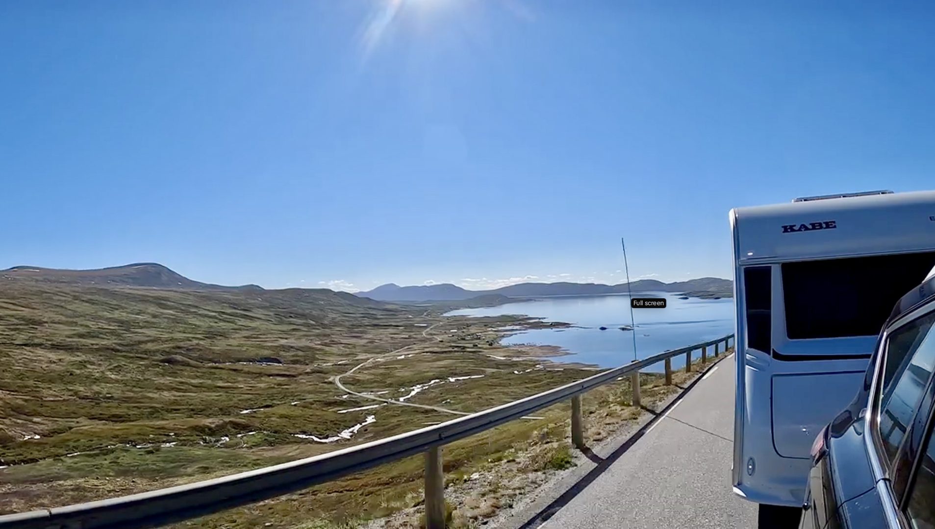 Autocamper og campingvogn på fjeldvej med sne i Norge Valdresflya